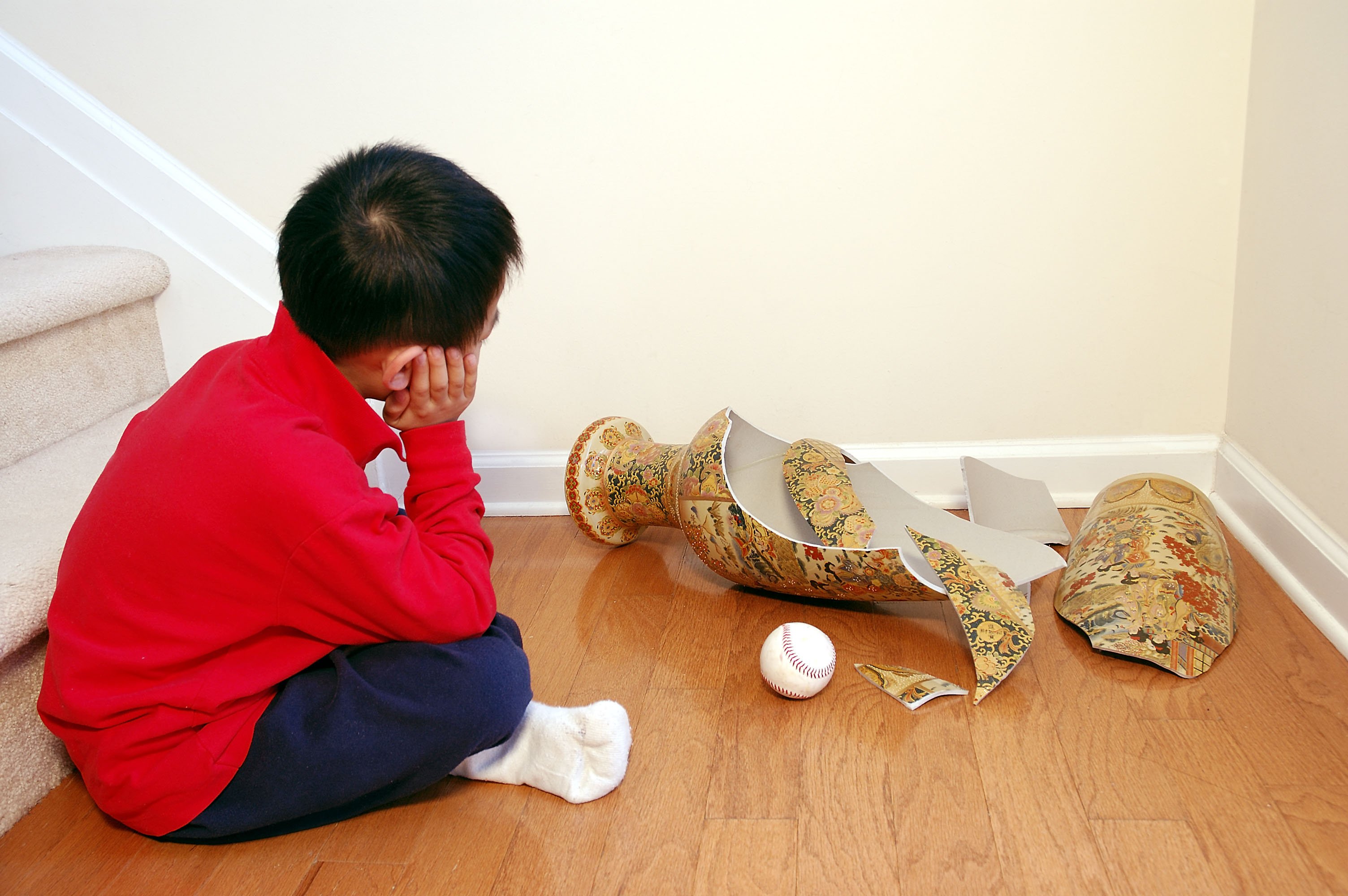 Boy next to broken vase